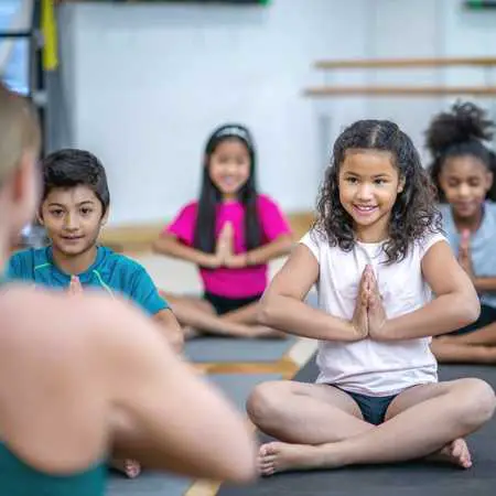 children sitting crossed legs in the meditation class