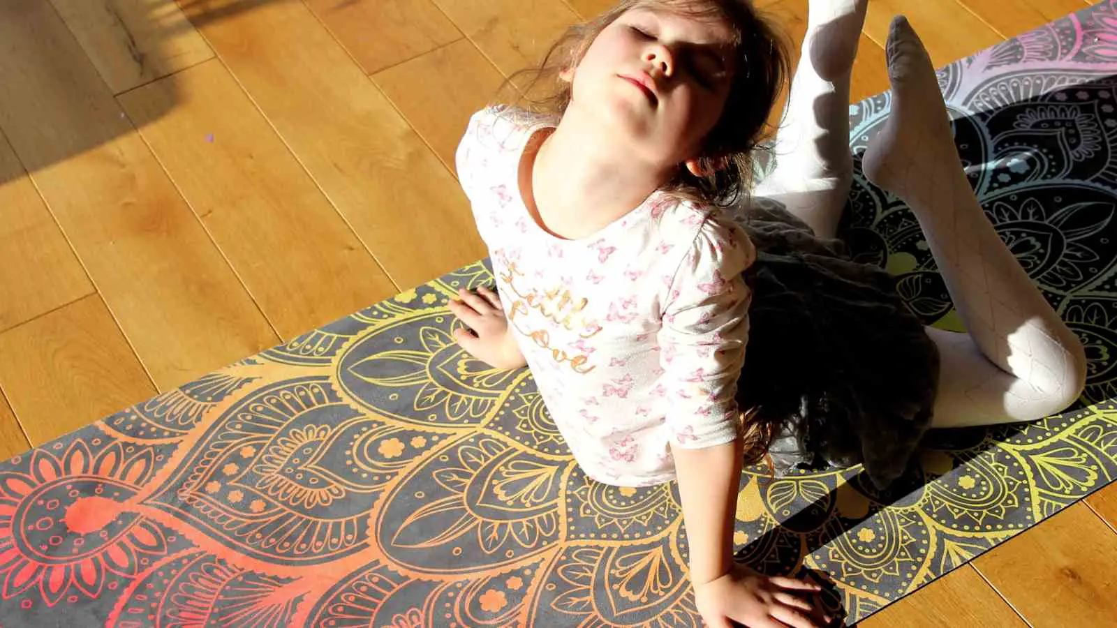 Little yogini on adult-size eco-friendly yoga mat